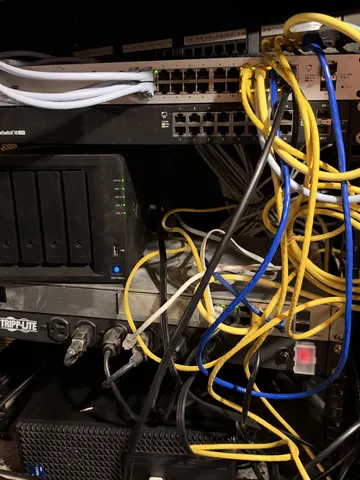 Before: network cabinet with long yellow and blue patch cables tangled across the switches, storage and power strip