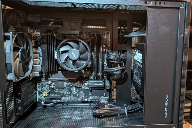 AMD Ryzen desktop in an ASUS Prime case with an ASRock motherboard and cables routed behind the tray