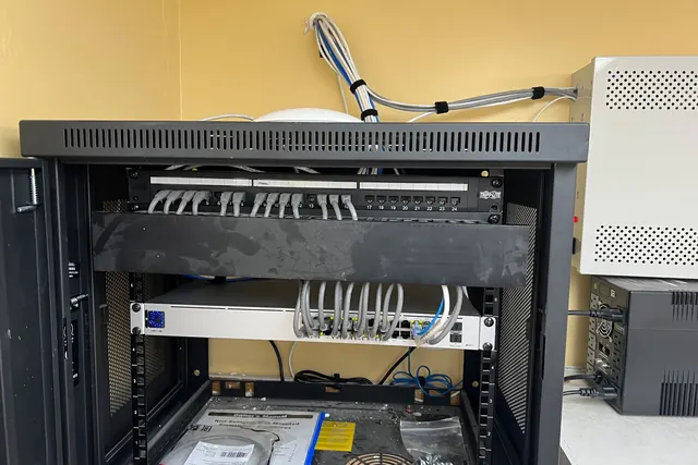 Wall-mounted network cabinet with short patch cables between the patch panel and switch