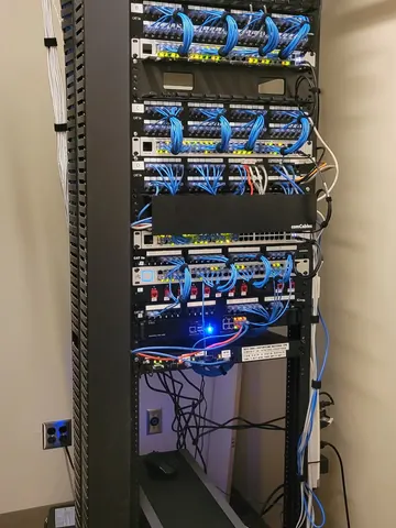 After: the same rack re-cabled with short, neat patch cords between each patch panel and switch
